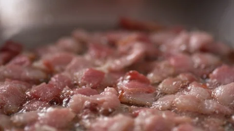 Camera follows adding chopped garlic on cooked bacon. Slow Motion. Stock Footage 104457423