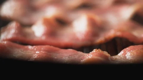 Camera follows adding salt on bacon cooked on grill. Slow Motion. Stock Footage 89815189