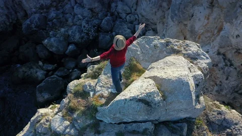 Camera follows around eldery man on top of rock in the sea.  Stock Footage 129599789