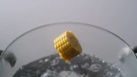 Camera follows cooking cut corn in boiling water. Slow Motion. Stock Footage 98317028