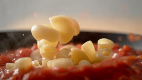 Camera follows cooking elbow macaroni pasta in tomato sauce. Slow Motion. Stock Footage 104453068