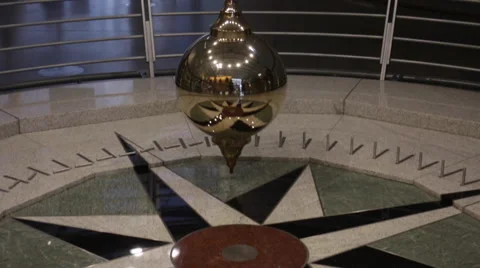 Camera follows a Foucault pendulum as it swings Stock Footage 47329065