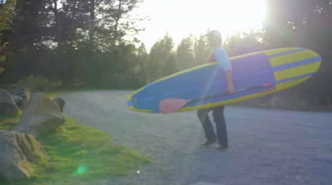Camera follows guy preparing to paddleboard Stock Footage 63385848
