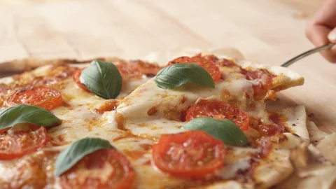 Camera follows a hand picking up a slice of pizza. Slow Motion. Stock Footage 121494532