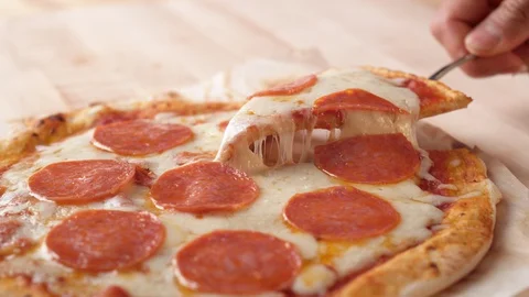 Camera follows a hand picking up a slice of pizza. Slow Motion. Stock Footage 128970491