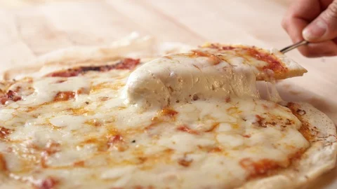 Camera follows a hand picking up a slice of pizza. Slow Motion. Stock Footage 128970973