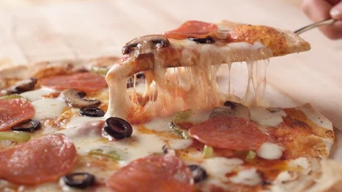 Camera follows a hand picking up a slice of pizza. Slow Motion. Stock Footage 128971254