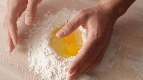 Camera follows mixing eggs and flour with hands. Slow Motion. Stock Footage 104459501