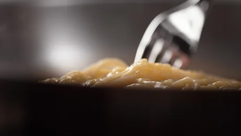 Camera follows mixing spaghetti with bacon, cream sauce. Slow Motion. Stock Footage 104458283
