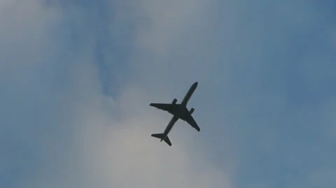 Camera follows a plane flying across a blue sky Stock Footage
