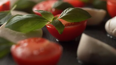 Camera follows putting basil on tomato, mozzarella cheese. Slow Motion. Stock Footage 104459433
