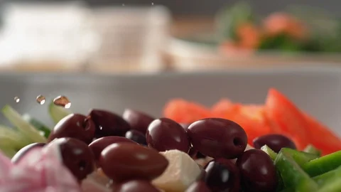 Camera follows putting dressing over greek salad. Slow Motion. Stock Footage 104460508