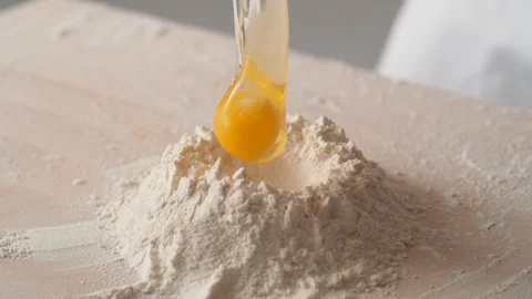 Camera follows putting egg in a pile of flour. Slow Motion. Stock Footage 104459205