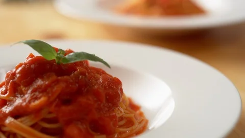 Camera follows putting fresh basil on tomato sauce pasta. Slow Motion. Stock Footage 104457321