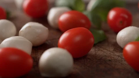 Camera follows putting fresh basil on tomato, mozzarella cheese. Slow Motion. Stock Footage 104459991