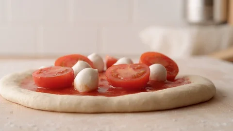 Camera follows putting a fresh basil leaf on a pizza dough. Slow Motion. Video stock 121493853