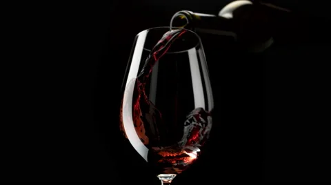 Camera follows red wine pouring into glass. Slow Motion. Stock Footage