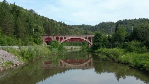 The camera follows the river under the bridge. 스톡 동영상 112856319