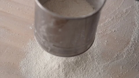 Camera follows sifting flour. Slow Motion. Video stock 104459258