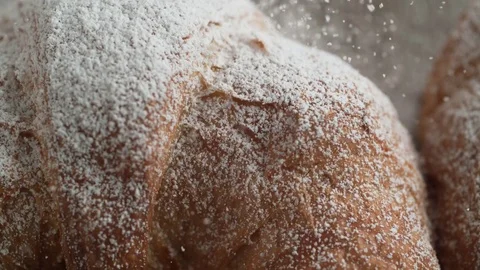 Camera follows sprinkling powered sugar over croissant. Slow Motion. Video stock 84937780