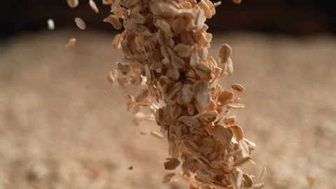 Camera follows throwing oats over a pile of oats. Slow Motion. Stock Footage 94084816