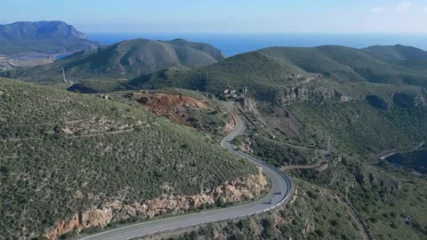 Camera follows two motorcyclists riding on serpentine road in mountains Stock Footage 230949865
