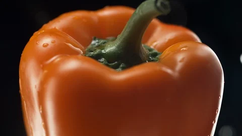Camera follows water splash on an orange pepper. Slow Motion. Stock Footage