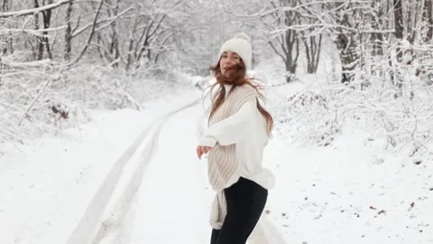 Camera follows a young long-haired woman girl running through the snowy forest Stock Footage 253088538