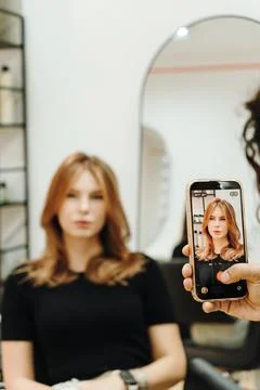 Camera frames a woman with her finished salon hairstyle Stock-Fotos