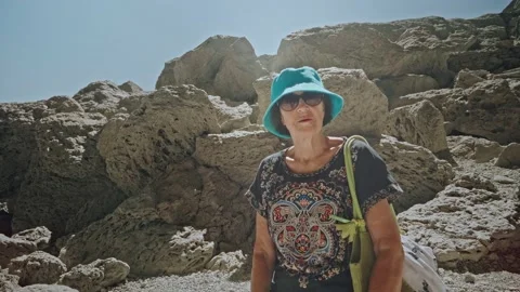 Camera getting closer to Happy senior lady standing on mountain hiking trail Stock-Footage 201261215