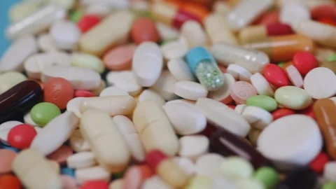 Camera gildes over pile of colorful medication pills Stock Footage 95480190