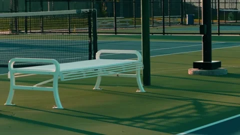 Camera Glides Toward an Empty Bench on a Tennis Court Stockbeeldmateriaal 339137190