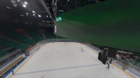 Camera glides under ceiling of ice arena covering screens and empty stands Видео 303278454