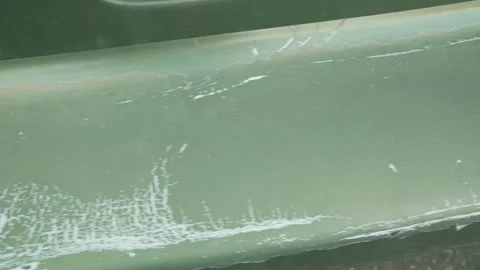 Camera gliding over the rusty bumper of an old green car showing paint damage Stock Footage 323715728