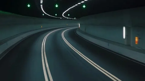 Camera gliding smoothly forward through dark curved modern highway tunnel. Video stock 344242329
