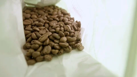 Camera goes into coffee bag and beans pour onto lens Stock Footage 98377147