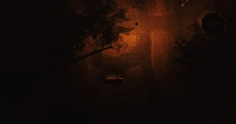 Camera goes down in mystery light near mysterious man who's sitting in the park. Stock Footage 68845792