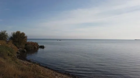 The camera goes down to the water. Sea panorama. Horizon. Sunny. Sea. 動画素材 167503199