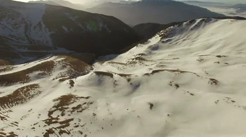 The camera goes over snowy mountains. The camera goes back. Aerial  video. N. Stock Footage 63474430