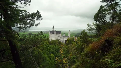 Camera goes through the trees on the hill to the Neuschwanstein Castle Stock Footage 120732054