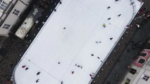 Camera going up while spinning under ski rink at city center Stock Footage 145594565