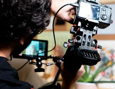 CAMERA GUY CHICO MANEJANDO UNA SONY A7III CON UN MONITOR EN UN RODAJE Foto stock
