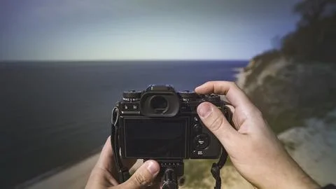 Camera in hands from the first person, landscape photography Stock Photos