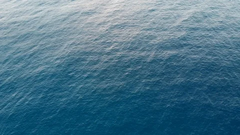 Camera hangs over the blue open calm sea water Stock Footage 101486175