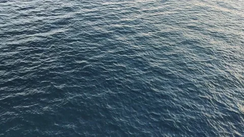 Camera hangs over the blue open calm sea water Stock Footage 143246320