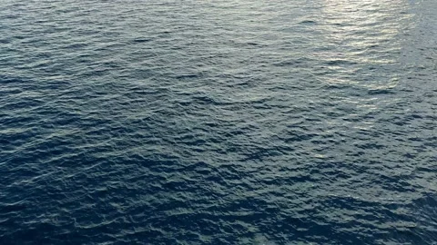 Camera hangs over the blue open calm sea water Stock Footage 143246352