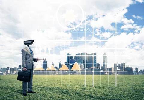 Camera headed man standing on green grass against modern citysca Stock Photos