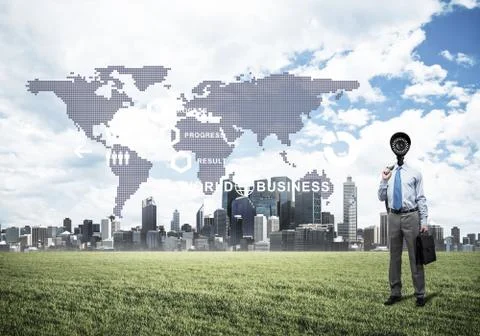 Camera headed man standing on green grass against modern citysca Stock Photos