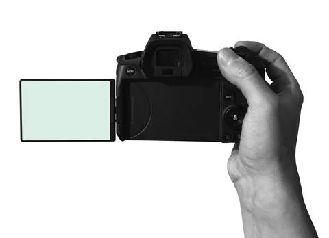 Camera held in hand with a screen flipped open against a white background Stock Photos
