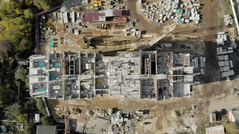 The camera hoisted over the construction site with workers and a crane. Stock Footage 96372480